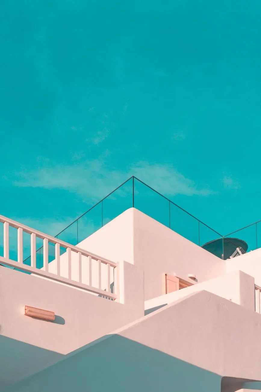 Pale pink building with a glass balustrade against a turquoise sky